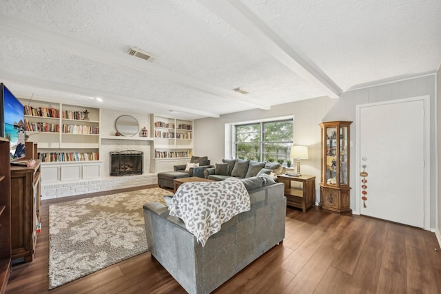 living room featuring beamed ceiling, a textured ceiling, dark hardwood / wood-style floors, and a fireplace