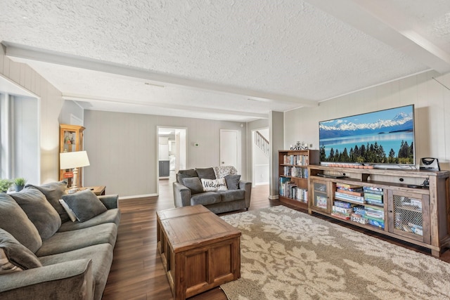 living room with beamed ceiling, a textured ceiling, dark hardwood / wood-style floors, and wooden walls