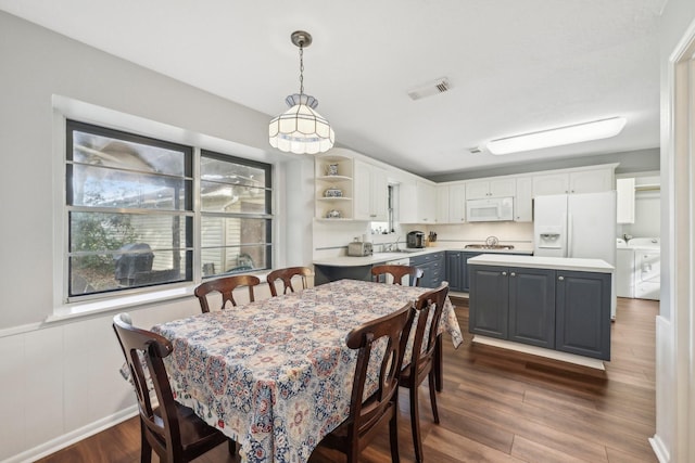 dining space featuring dark hardwood / wood-style flooring and washer and clothes dryer