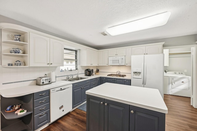 kitchen with white cabinetry, sink, dark hardwood / wood-style flooring, white appliances, and a kitchen island