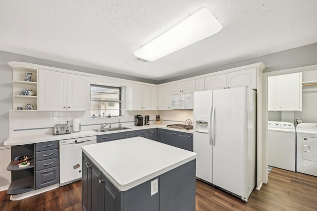 kitchen featuring white cabinets, white appliances, and washer and clothes dryer