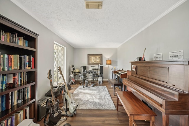 misc room with a textured ceiling, dark hardwood / wood-style floors, and ornamental molding