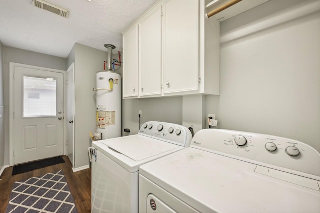 washroom featuring cabinets, dark wood-type flooring, independent washer and dryer, a textured ceiling, and water heater