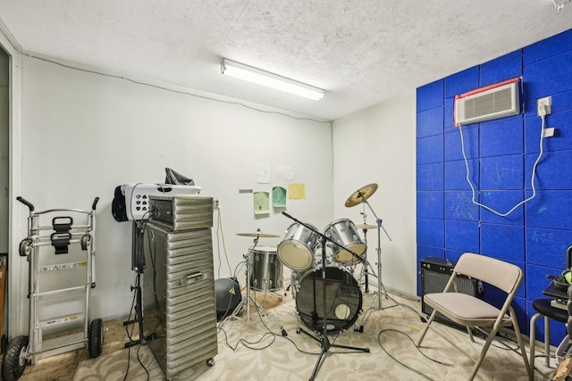 miscellaneous room with a textured ceiling and a wall mounted AC