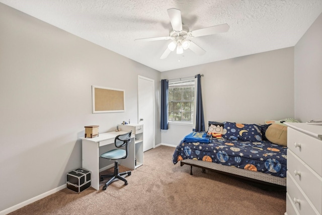 bedroom with ceiling fan, carpet floors, and a textured ceiling