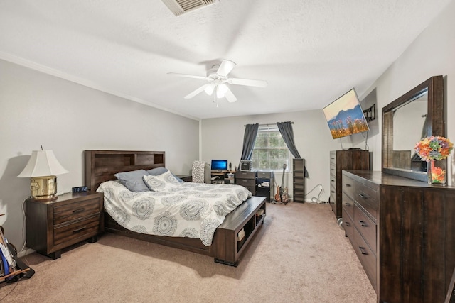 bedroom with a textured ceiling, ceiling fan, and light carpet