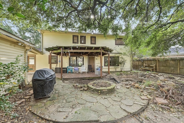 rear view of house with a pergola, a fire pit, and a deck