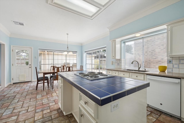 kitchen with tile countertops, white dishwasher, a sink, visible vents, and stainless steel cooktop