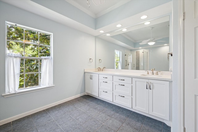 bathroom with ceiling fan, a sink, baseboards, a shower stall, and crown molding