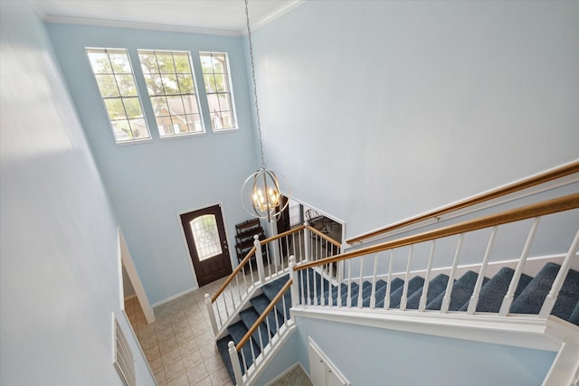 staircase with baseboards, a chandelier, and ornamental molding