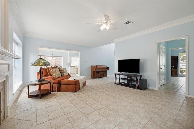 living area featuring a fireplace, crown molding, visible vents, baseboards, and ceiling fan with notable chandelier