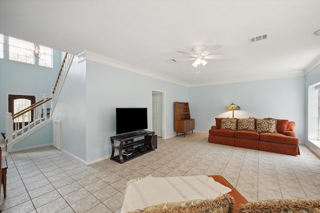 living area featuring light tile patterned flooring, visible vents, baseboards, ornamental molding, and stairway