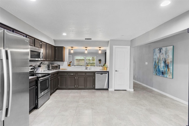 kitchen with appliances with stainless steel finishes, dark brown cabinetry, a textured ceiling, sink, and light tile patterned floors