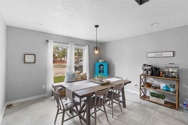 tiled dining space with a textured ceiling