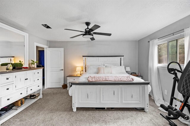 carpeted bedroom with a textured ceiling and ceiling fan