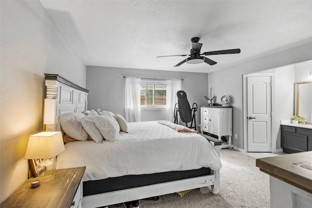 carpeted bedroom featuring ceiling fan and a textured ceiling