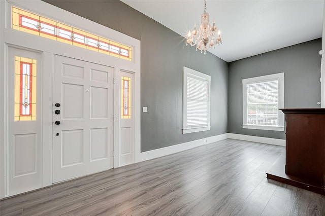 foyer entrance with light hardwood / wood-style floors and a notable chandelier