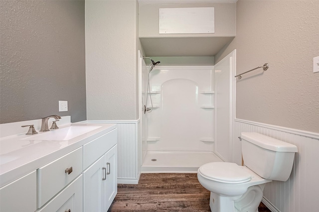 bathroom featuring wood-type flooring, vanity, toilet, and walk in shower