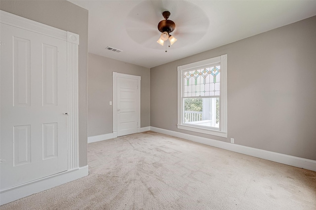 empty room featuring light colored carpet and ceiling fan