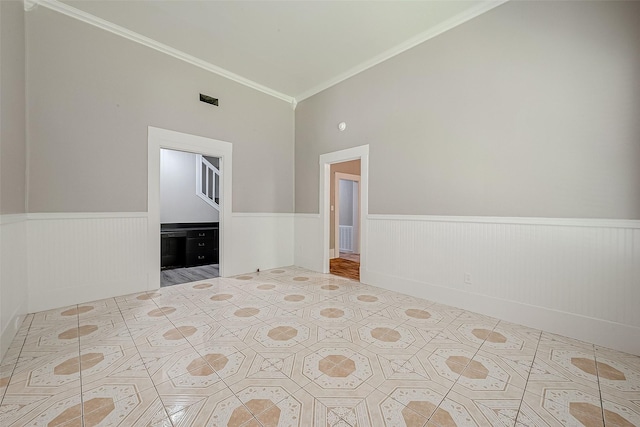 spare room with ornamental molding and vaulted ceiling