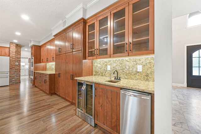 kitchen featuring light wood-type flooring, tasteful backsplash, sink, dishwasher, and wine cooler