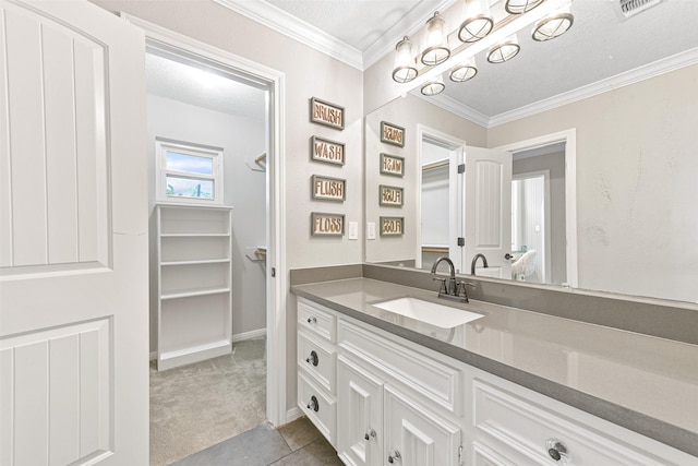 bathroom with vanity, a textured ceiling, tile patterned floors, and crown molding