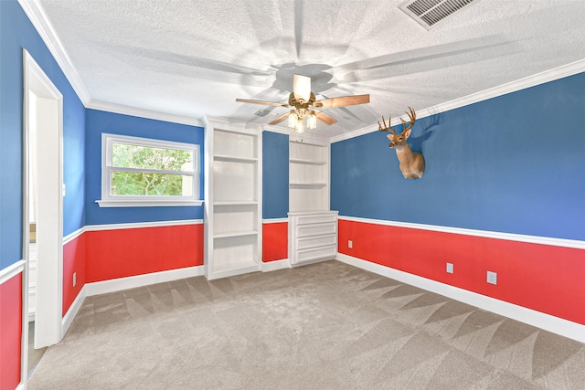 carpeted spare room featuring a textured ceiling, ceiling fan, and crown molding