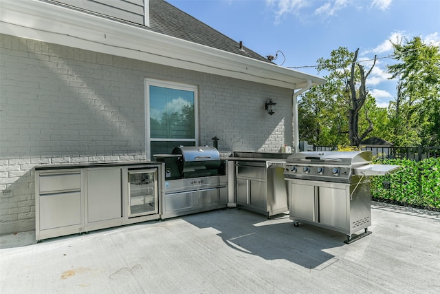 view of patio with beverage cooler, exterior kitchen, and grilling area