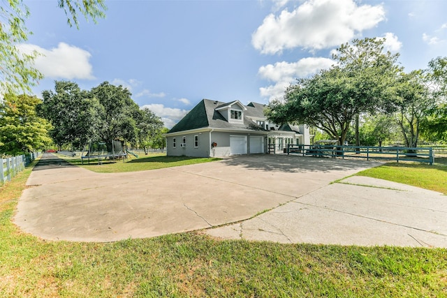 view of home's exterior with a yard, a garage, and a trampoline