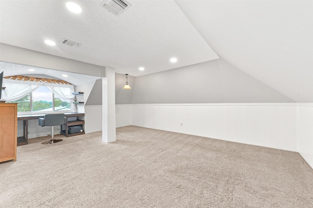 bonus room featuring carpet, a textured ceiling, and vaulted ceiling