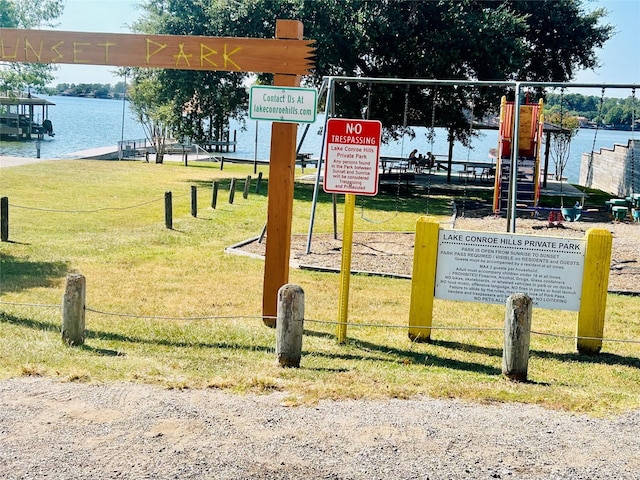 view of home's community with a lawn and a water view