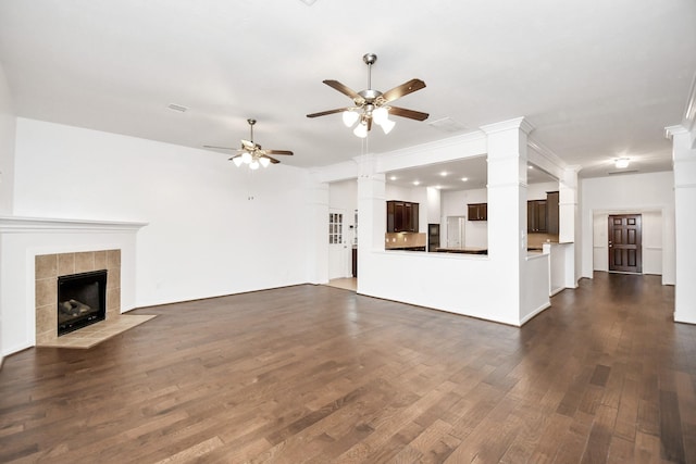 unfurnished living room featuring ceiling fan, dark hardwood / wood-style flooring, and a tiled fireplace