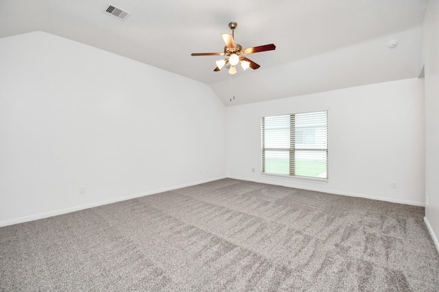 carpeted spare room featuring ceiling fan and vaulted ceiling