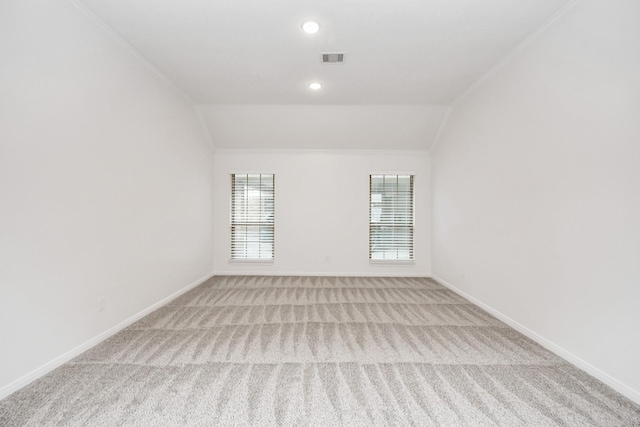 empty room featuring light carpet and vaulted ceiling