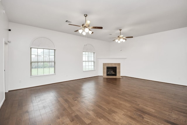 unfurnished living room with a fireplace, ceiling fan, and dark wood-type flooring