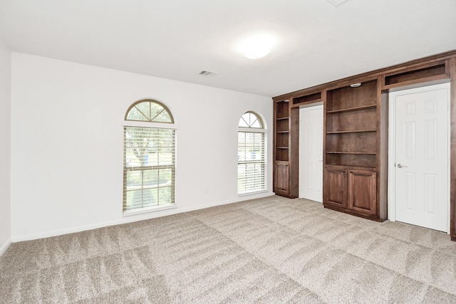 unfurnished bedroom featuring light carpet and a closet