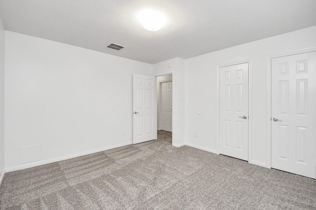 unfurnished bedroom with carpet and a textured ceiling