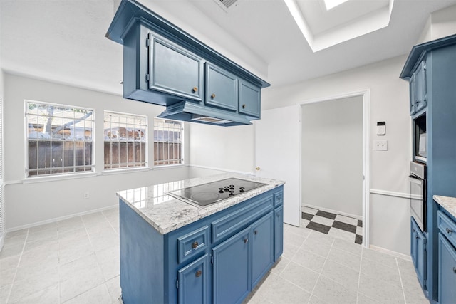 kitchen with light stone countertops, black electric stovetop, a skylight, blue cabinetry, and oven