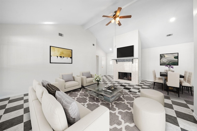 living room with beam ceiling, a tile fireplace, ceiling fan, and high vaulted ceiling