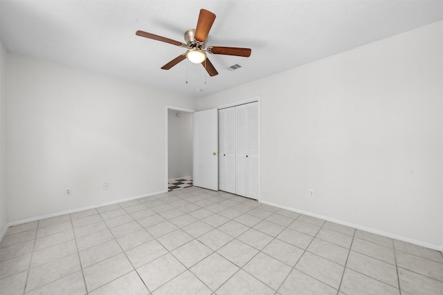 unfurnished bedroom featuring ceiling fan, a closet, and light tile patterned flooring