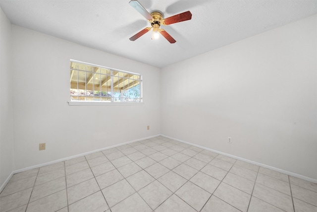 tiled spare room with a textured ceiling and ceiling fan