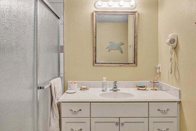 bathroom featuring vanity and a shower with door