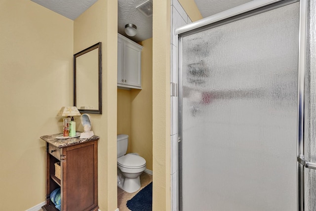 bathroom with walk in shower, a textured ceiling, and toilet