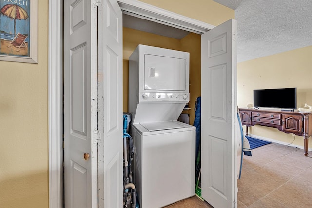 818 Sea Shell Dr, Freeport, TX 77541 - laundry area featuring light tile patterned floors, a textured ceiling, and stacked washer and clothes dryer