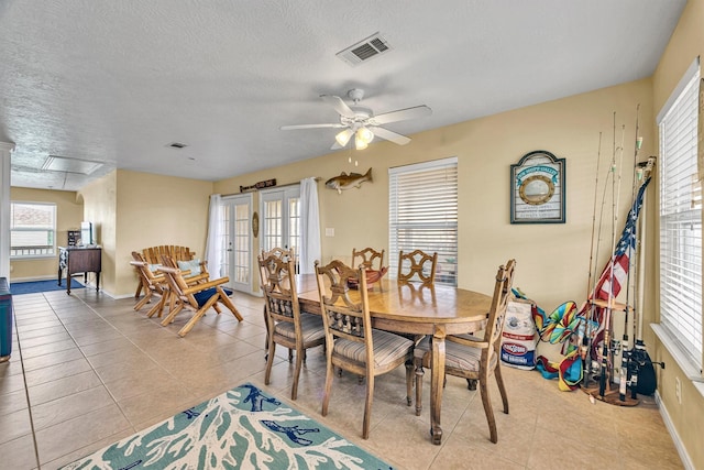 tiled dining space featuring ceiling fan and a textured ceiling