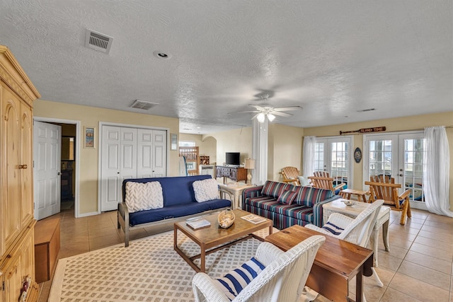 living room featuring ceiling fan, light tile patterned flooring, a textured ceiling, and french doors