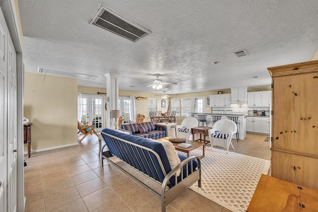 818 Sea Shell Dr, Freeport, TX 77541 - living room featuring ceiling fan, plenty of natural light, light tile patterned flooring, and a textured ceiling