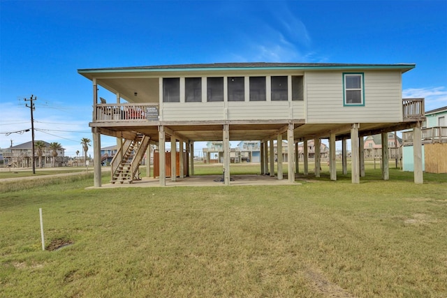 back of property featuring a lawn, a patio area, and a sunroom