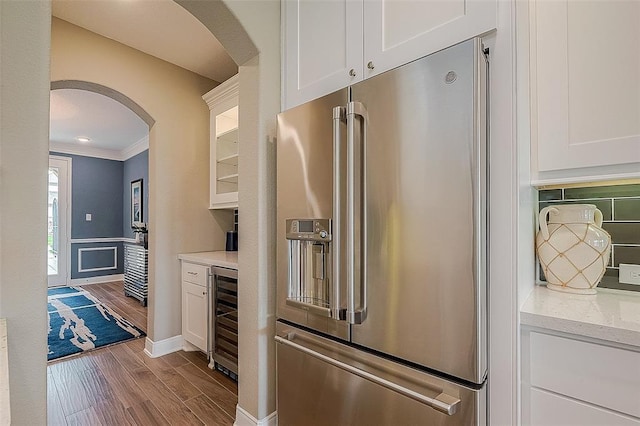 kitchen featuring white cabinetry, light wood-type flooring, beverage cooler, and high end refrigerator