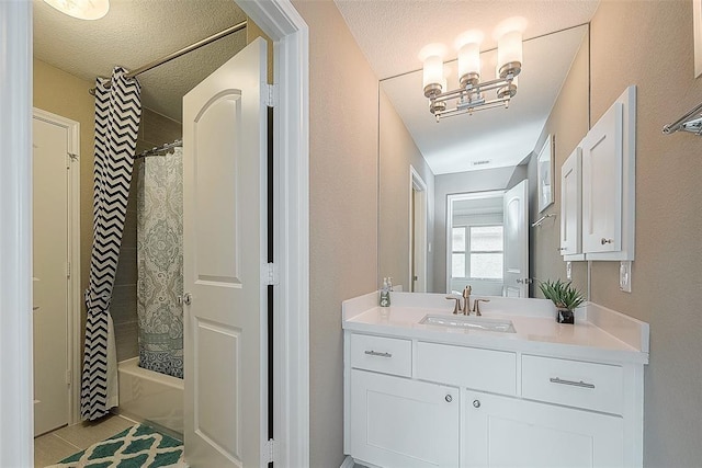 bathroom with tile patterned flooring, vanity, a textured ceiling, and shower / tub combo with curtain